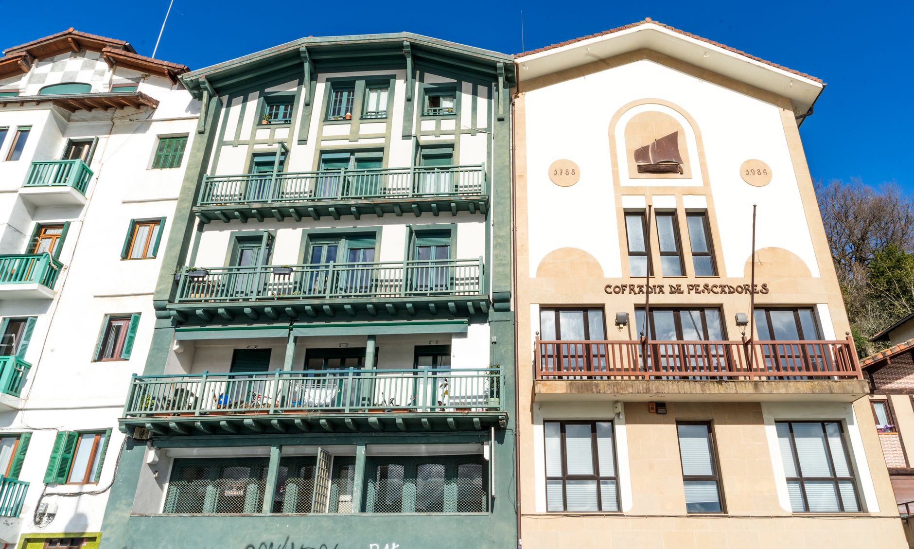 Vibrant buildings in a sunny Spanish coastal town showcasing traditional architecture.