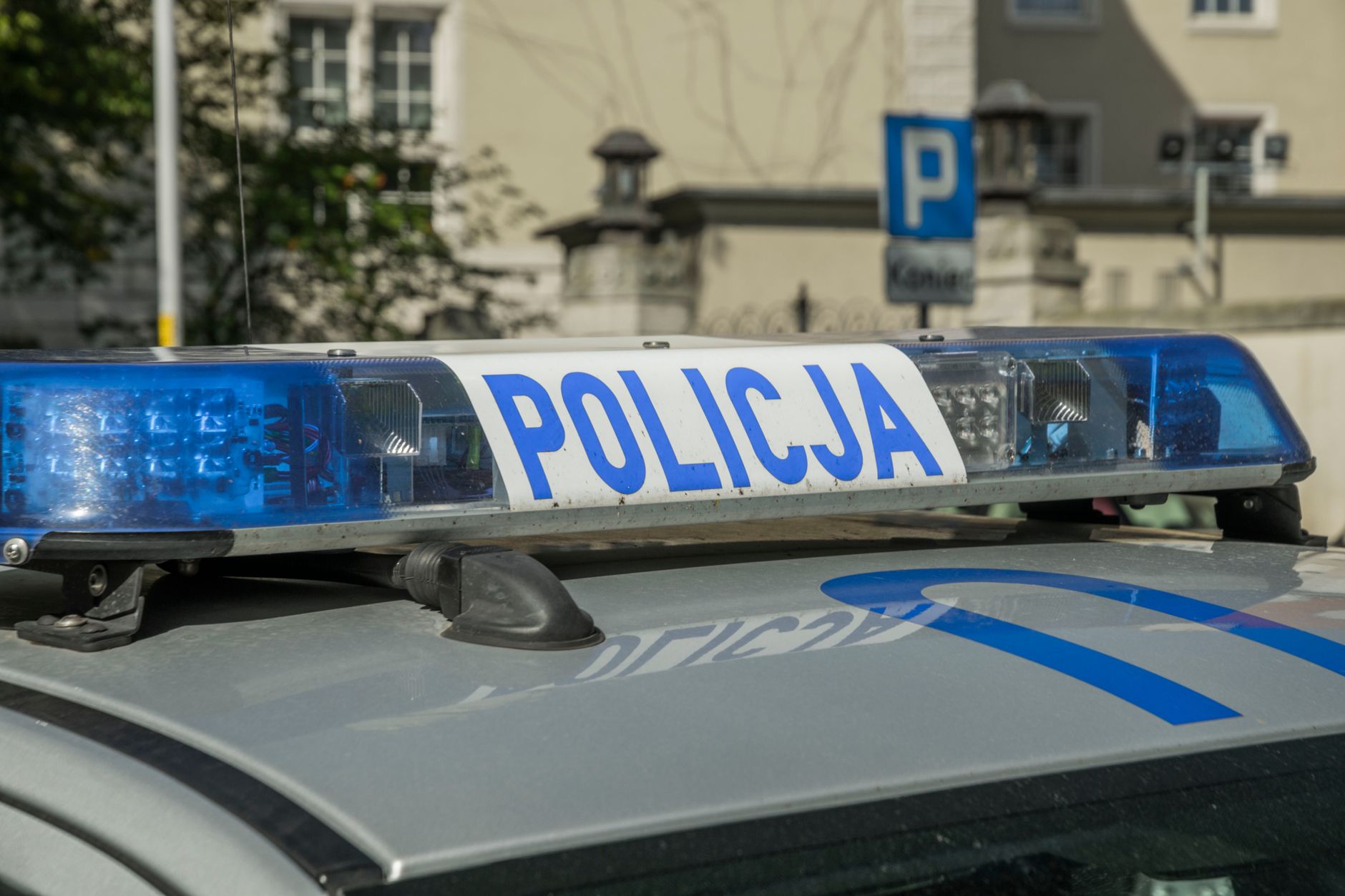 A close-up image showing the light bar of a Polish police car with the word 'Policja'.